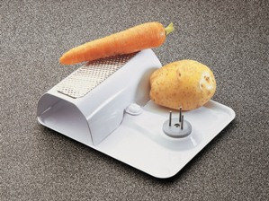 Vegetable scraper on foot with fixation nails